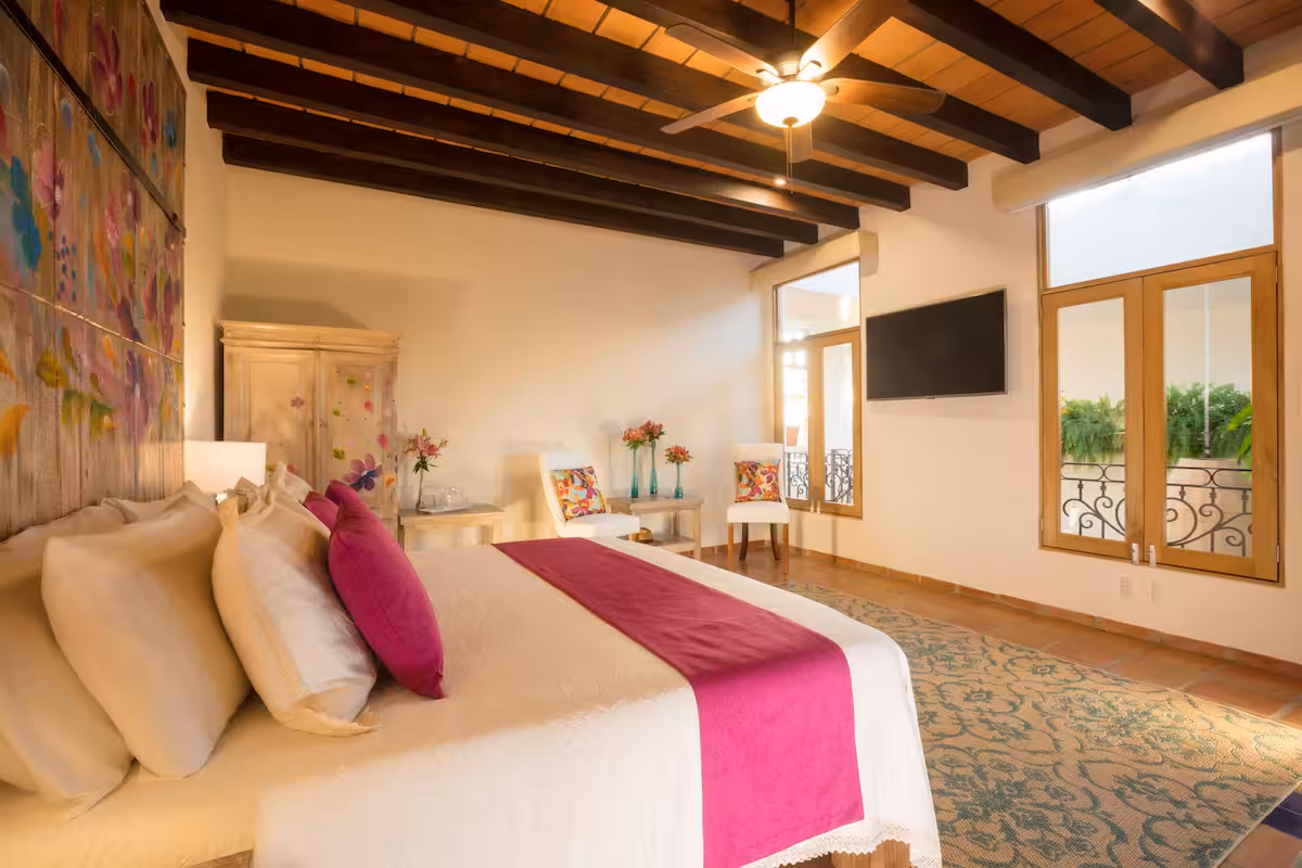 Bedroom with a pink bed runner and sitting area