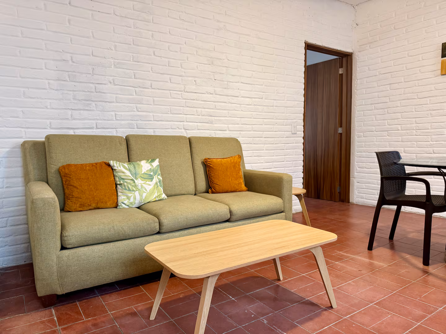 Green sofa and coffee table beside the dining area